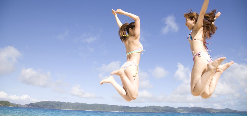 グアムのビーチでジャンプする女性